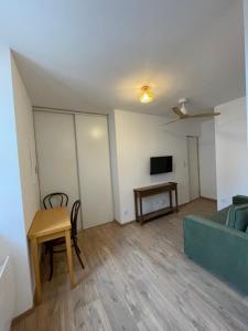 ein Wohnzimmer mit Sofa und Tisch in der Unterkunft Le petit cosy in Saint-Paul-Trois-Châteaux