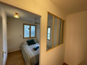 ein kleines Schlafzimmer mit einem Bett und einem Fenster in der Unterkunft Le petit cosy in Saint-Paul-Trois-Châteaux + 4 Fotos