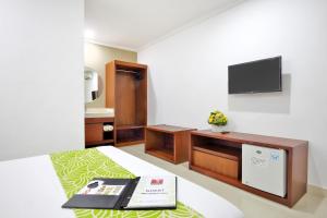 Televízia a/alebo spoločenská miestnosť v ubytovaní Dewi Sri Hotel