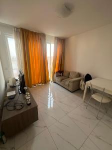 a living room with a couch and a table at Jasmine court penthouse in Tal-Ħriereb