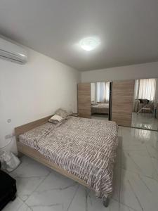 a bedroom with a bed with a striped comforter at Jasmine court penthouse in Tal-Ħriereb