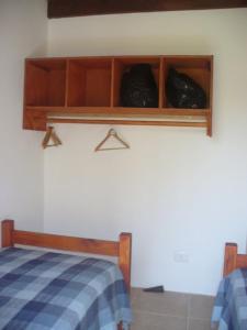 une chambre avec un lit et des étagères avec des sacs noirs dans l'établissement Casa en La Aguada Rocha, à La Aguada