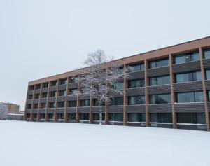 an office building with a tree in front of it at Hôtels Gouverneur Sept-Îles in Sept-Îles