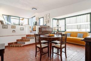 een keuken en woonkamer met een tafel en stoelen bij DIMORA DISIU - Jacuzzi & Sea View - 4 minuti a piedi dal centro in Taormina