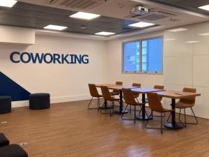 a conference room with tables and chairs and a company sign at Flats na praia com AC, piscina, sauna e academia! in Santos +51 photos