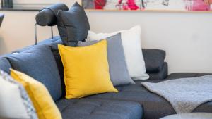 Un sofá azul con almohadas amarillas. en Ferienhaus Klopeiner See, en Unterburg am Klopeiner See 14 fotos más