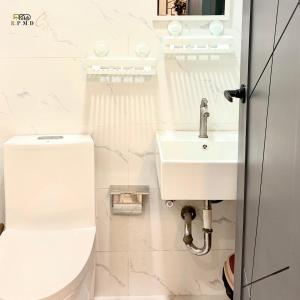 a white bathroom with a toilet and a sink at CJ Apartments-III in Olongapo