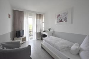 WangenにあるPension Lindeの白いリビングルーム(ソファ、テレビ付)