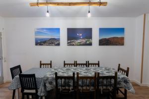 a dining room with a table and four pictures on the wall at El Salón de Arriba in El Real de San Vicente