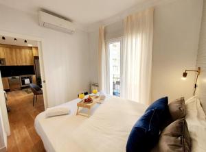 ein Schlafzimmer mit einem großen weißen Bett und einer Couch in der Unterkunft AH - Aparta Suites Madrid Río in Madrid