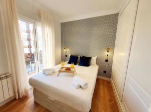 ein Schlafzimmer mit einem großen weißen Bett mit Handtüchern darauf in der Unterkunft AH - Aparta Suites Madrid Río in Madrid