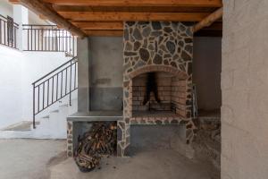 a stone fireplace in a room with a staircase at El Salón de Arriba in El Real de San Vicente