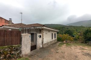 a small white house with a gate in front at El Salón de Arriba in El Real de San Vicente
