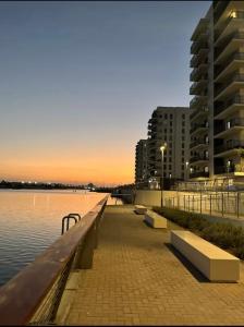 a sidewalk next to a body of water with buildings at Chez Teo in Abu Dhabi