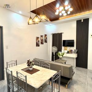 ein Esszimmer mit Tisch und Couch in der Unterkunft CJ Apartments-III in Olongapo