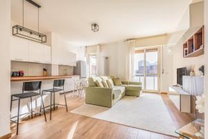 ein Wohnzimmer mit Couch und Küche in der Unterkunft Sesto Rondò Ospedale San Raffaele 4 Pax Wi-Fi in Sesto San Giovanni