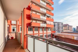 ein Wohnungsbalkon mit Blick auf ein orangefarbenes Gebäude in der Unterkunft Sesto Rondò Ospedale San Raffaele 4 Pax Wi-Fi in Sesto San Giovanni