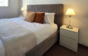 ein Schlafzimmer mit einem Bett mit zwei Lampen und einem Nachttisch in der Unterkunft City Heart Residence by Staycom in Nikosia + 2 Fotos