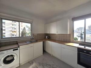 eine Küche mit weißen Schränken und einer Waschmaschine in der Unterkunft City Heart Residence by Staycom in Nikosia