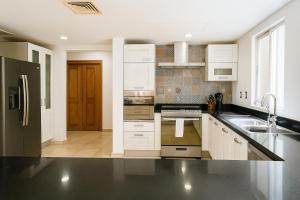 a kitchen with white cabinets and stainless steel appliances at 7BR Private Jacuzzi & Pool Villa Sleeps 16 Walk to Beach Lagoon and Golf in Puerto Aventuras