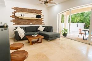 a living room with a couch and a surfboard on the wall at 7BR Private Jacuzzi & Pool Villa Sleeps 16 Walk to Beach Lagoon and Golf in Puerto Aventuras +39 photos