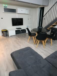 a living room with a table and chairs and a tv at Suites GREY in centro Randazzo in Randazzo