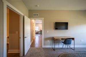 a home office with a desk and a television at Modern 2BR & 2BA New Build Condo w Garage & Patio in Grandville