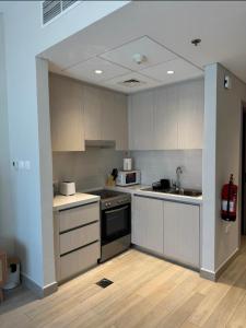 a kitchen with a sink and a stove top oven at Chez Teo in Abu Dhabi