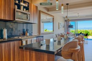een keuken met een tafel en stoelen erin bij Luxury 2BR Condo in Nuevo Vallarta - Rooftop Pool in Nuevo Vallarta 