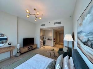 a living room with a bed and a tv at Chez Teo in Abu Dhabi