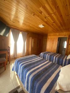 a bedroom with two beds and a wooden ceiling at Residencial Golden in Los Vilos