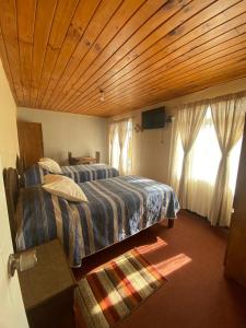 a bedroom with two beds and a wooden ceiling at Residencial Golden in Los Vilos
