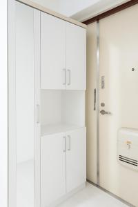 Una cocina con gabinetes blancos y un refrigerador. en r311 Spacious Apartment near Dotonbori Namba Walk to Nipponbashi, en Osaka