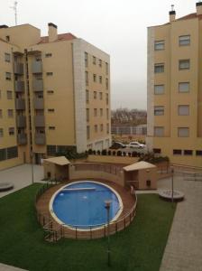 une piscine devant deux grands immeubles dans l'établissement Apartamento Los Lirios Logroño, à Logroño