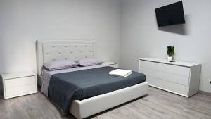 a white bedroom with a bed and two night stands at Suites GREY in centro Randazzo in Randazzo +4 photos