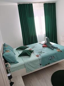 a bedroom with a bed with green curtains at Apartament HD3 in Hunedoara