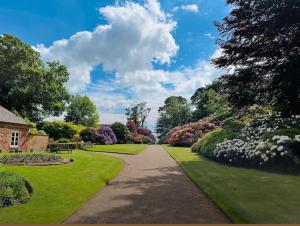 a walkway in a park with green grass and flowers at The Citadel in Weston