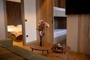 a living room with a vase of flowers on a table at Apart-hotel Pahulja in Jahorina