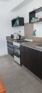 a kitchen with black cabinets and a counter top at Departamento Pepper in Trelew