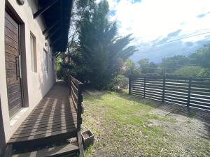 a wooden walkway next to a house with a fence at Cabañas Cruz del Sur in Miramar +5 photos