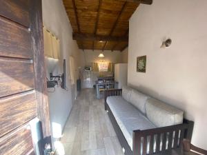 a living room with a couch and a kitchen at Cabañas Cruz del Sur in Miramar