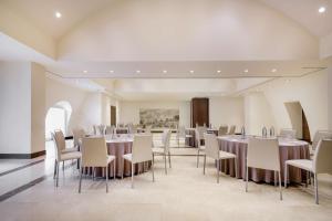 a dining room with tables and chairs in a room at NH Collection Palacio de Aranjuez in Aranjuez