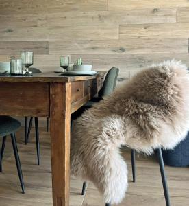 una mesa de comedor con una alfombra de piel sintética encima en Boutique apartment Chaberton view - R16, en San Sicario