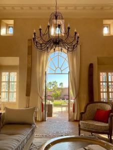 a living room with a chandelier and a large window at Villa Cannella in Najem