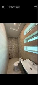 a bathroom with a sink and a toilet and a window at Canal road in Faisalabad