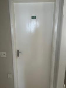 a door with a clock on the side of it at Suíte 06 no centro da cidade in Uberaba