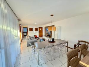 a kitchen and living room with a table and chairs at Cobertura 3Q ILOA Barra de S Miguel Castelo B Temporada in Barra de São Miguel +51 photos