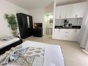 Habitación con cama y cocina con microondas. en Nice condo with fresh pool, en Punta Cana