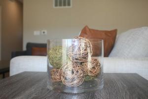 a glass vase filled with plants on a table at Modern 2BR & 2BA Condo with Garage & Patio in Grandville
