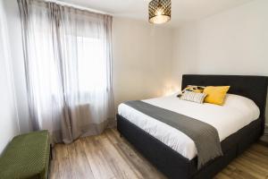 a bedroom with a bed with yellow pillows and a window at Etxea iradi in Elejalde